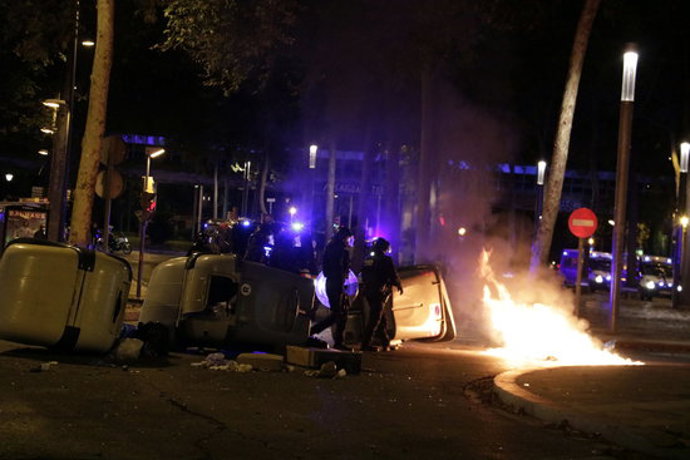Els antiavalots dels Mossos passant per davant d'uns contenidors incendiats a Girona, l'1 d'octubre del 2020 (horitzontal)