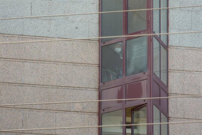 Un trabajador protegido es visto por uno de los cristales de la residencia de mayores DomusVi de Outeiro de Rei en Lugo, Galicia (España), a 8 de septiembre de 2020. La Xunta ha intervenido el geriátrico tras detectar 99 positivos más en covid-19, 94 de