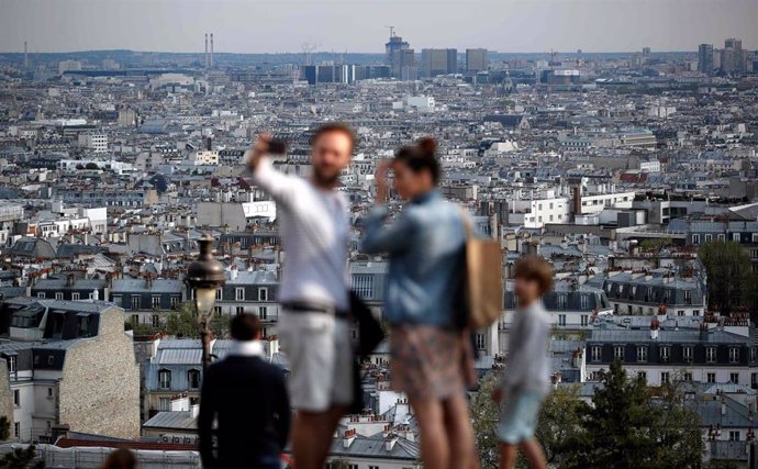Una familia se hace un foto con su teléfono móvil desde Montmartre (París)