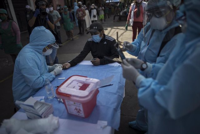Un trabajador sanitario toma muestras en Lima, Perú.