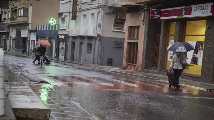 Vecinos del municipio de San Adrián caminan protegidos con un paraguas, Navarra (España), a 2 de octubre de 2020. 