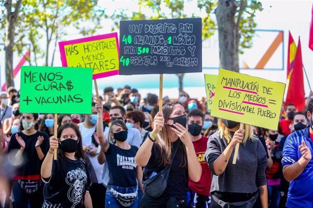 Varias personas sostienen carteles durante una concentración bajo el nombre ‘Más Sanidad, Menos Policía’ frente a la Asamblea de Madrid en el barrio madrileño de Vallecas.