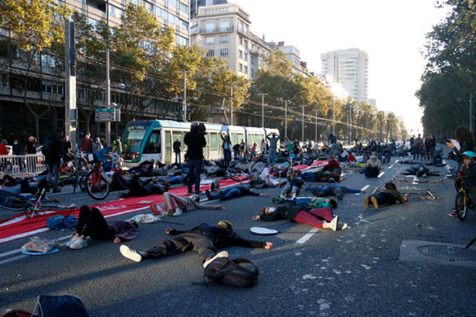 Diverses persones simulen les morts per la contaminació de l'aire en una 'performance' a la Diagonal per reclamar la reducció del vehicle privat a Barcelona. Imatge del 3/10/2020 (horitzontal)