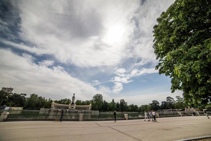 Varias personas pasean protegidas con mascarillas después de la reapertura del Parque de El Retiro tras haber sido cerrado por el Ayuntamiento de Madrid junto con otros parques históricos de la ciudad este domingo 31 de mayo al activarse la alerta roja 