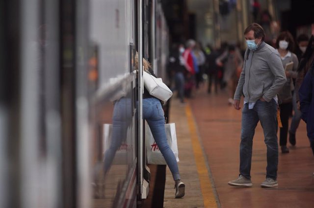 Una mujer sube a un tren en la Estación de Madrid-Puerta de Atocha Adif, en Madrid (España), a 28 de septiembre de 2020. Más de un millón de madrileños, que representan el 15,4 por ciento de la población de la región, verán desde este hoy restringida su m