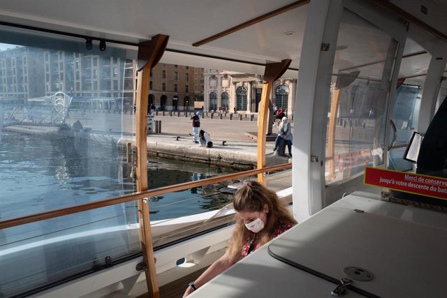 Mujer con mascarilla a bordo de una embarcación en Marsella, Francia
