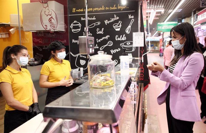 La vicealcaldesa de Madrid, Begoña Villacís (d), habla con dos trabajadoras de una tienda durante su visita al mercado de Santa María de la Cabeza, en Madrid (España)