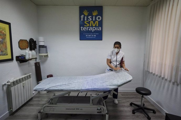 Una fisioterapeuta ciega de la Clínica Fisio SM Terapia (calle Covarrubias, 35) prepara la camilla de un paciente en el primer día de la fase 1 de la desescalada en Madrid. La Clínica Fisio SM Terapia (calle Covarrubias, 35) reabrió sus puertas en Madri