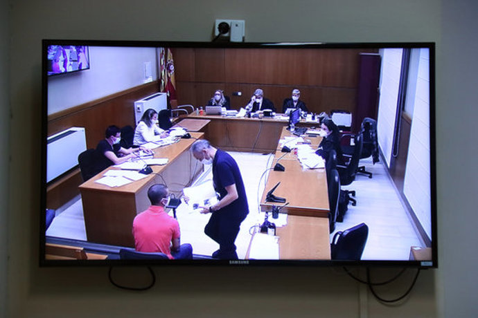 Un acusat comprova la seva presncia en una foto durant el judici contra tres acusats de desordres públics i atemptat el gener del 2018 a la Ciutadella, en una fotografia de la pantalla de la sala de premsa del TSJC. (Horitzontal)