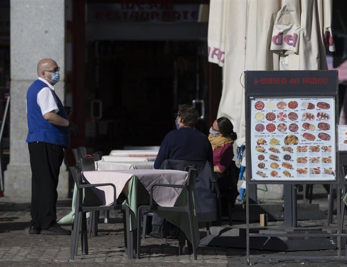 Un camarero atiende la terraza de un establecimiento ubicado en la Plaza Mayor durante el primer día con nuevas restricciones en la movilidad, en Madrid, (España), a 3 de octubre de 2020.