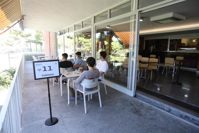 Varios colegiales del Colegio Mayor Aquinas descansan en una zona habilitada donde se observa un cartel indicativo del aforo permitido, en Madrid, (España), a 10 de septiembre de 2020. El centro, que cuenta con 165 colegiales, ha seguido la Guía Recome