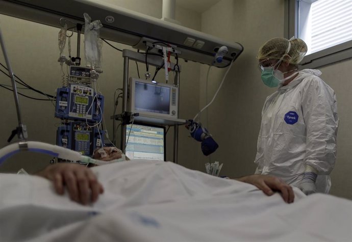 Personal sanitario totalmente protegido atiende a un paciente ingresado en la Unidad de Cuidados Intensivos del Hospital Infanta Sofía en San Sebastián de los Reyes 