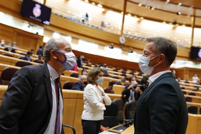El ministro de Justicia, Juan Carlos Campo (i), habla con el portavoz del PSOE en el Senado, Ander Gil (d), momentos antes del inicio de una sesión de control al Gobierno en la Cámara Alta, en Madrid (España), a 6 de octubre de 2020. 