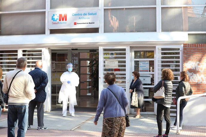 Una sanitaria sale a atender a las numerosas personas que hacen cola en el Centro de Salud Vicálvaro-Artilleros en el distrito de Vicálvaro