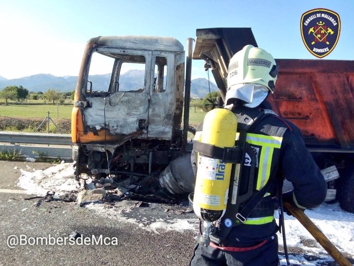 Un bombero trabaja en apagar el fuego del camión que ha ardido en la autopista que une Palma con Inca.