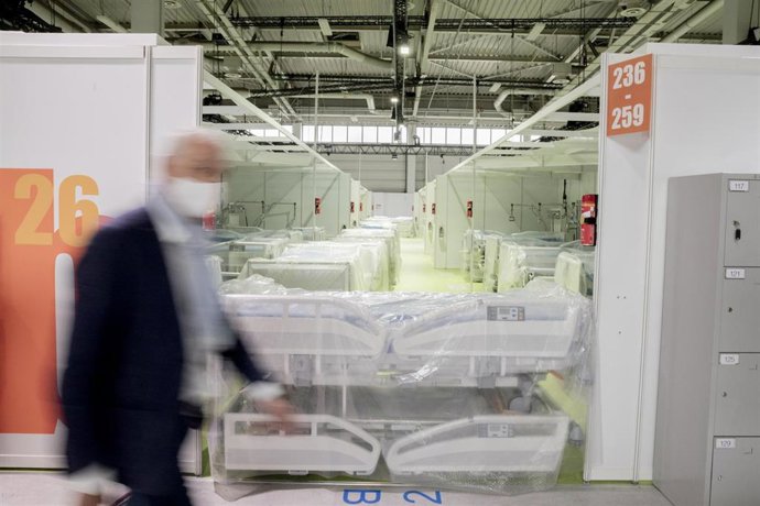 Un hombre pasa ante una sala con camas de hospital en un centro de tratamiento de coronavirus en exhibición en Berlín