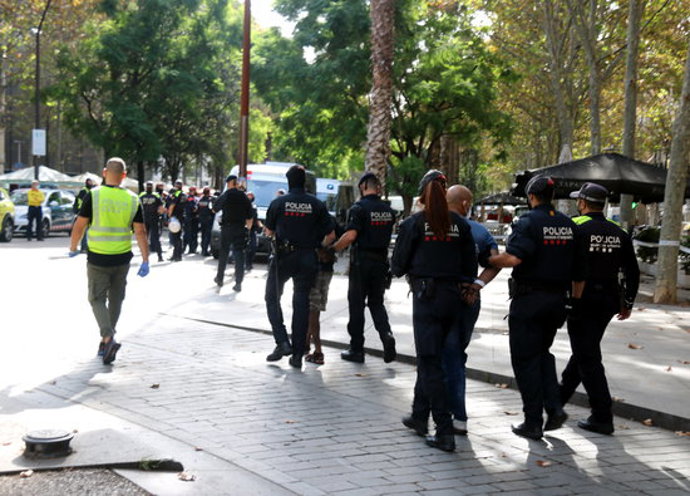 Pla mitj de diversos detinguts al Raval conduts caminant per mossos d'Esquadra, el 7-10-20 (horitzontal).