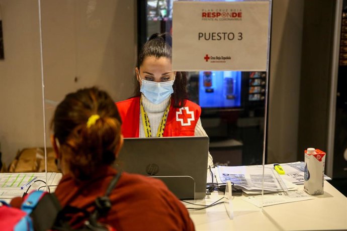 Trabajadores atienden en su mesa de trabajo en la sede de Cruz Roja Española en San Sebastián de los Reyes, Madrid (España), a 2 de octubre de 2020.