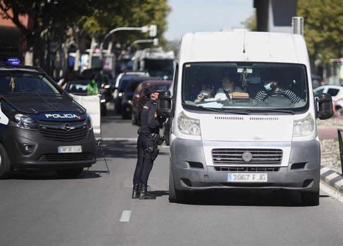 Una agente de la Policía Nacional para a un vehículo durante un control policial de movilidad en Madrid (España).