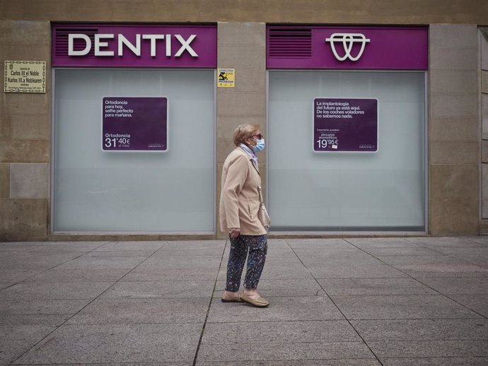 Una mujer pasa frente a una clínica de Dentix.