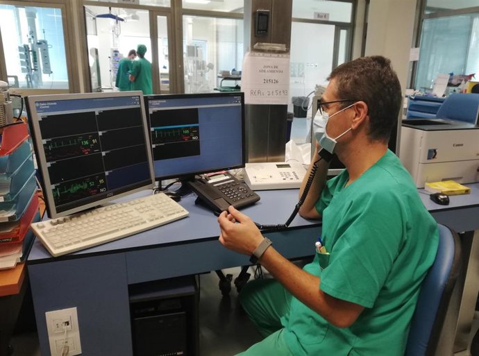 Uno de los trabajadores de la UCI del Hospital Infanta Elena de Huelva informa a los familiares de los pacientes aislados sobre su estado de salud.