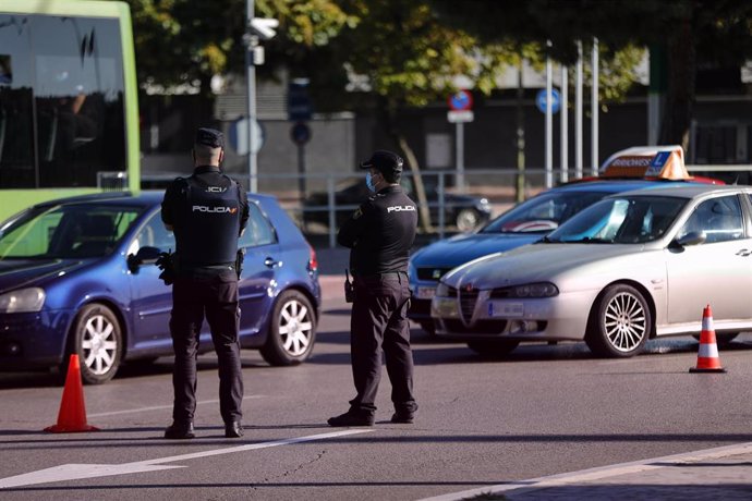 Dos agentes de la Policía Nacional durante un control policial en una calle de Móstoles, Madrid (España), a 7 de octubre de 2020. Hoy es el tercer día laborable desde que entraron en vigor -el viernes 2 de octubre a las 22.48h.- las restricciones de mov