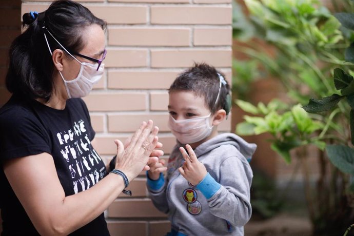 Hugo Romero, un niño sordo, utiliza una mascarilla transparente certificada -pero no homologada por el Ministerio de Sanidad- con la que se comunica con su madre Elena Alvarez, en Villaverde, Madrid, (España), a 18 de septiembre de 2020. 
