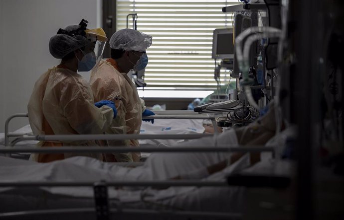 Dos sanitarios atienden a un paciente en la Unidad de Cuidados Intensivos (UCI) dedicada a enfermos de coronavirus del Hospital Universitario Ramón y Cajal, en Madrid (España), a 8 de octubre de 2020. Durante esta segunda oleada de la pandemia en España