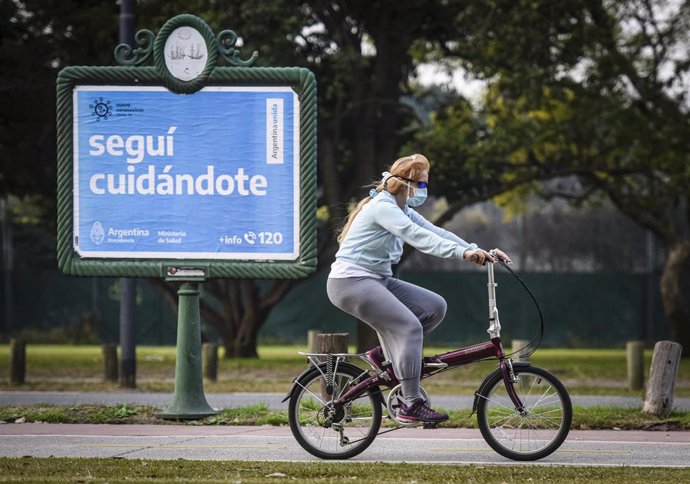 Una mujer pasea en bicicleta por Buenos Aires.