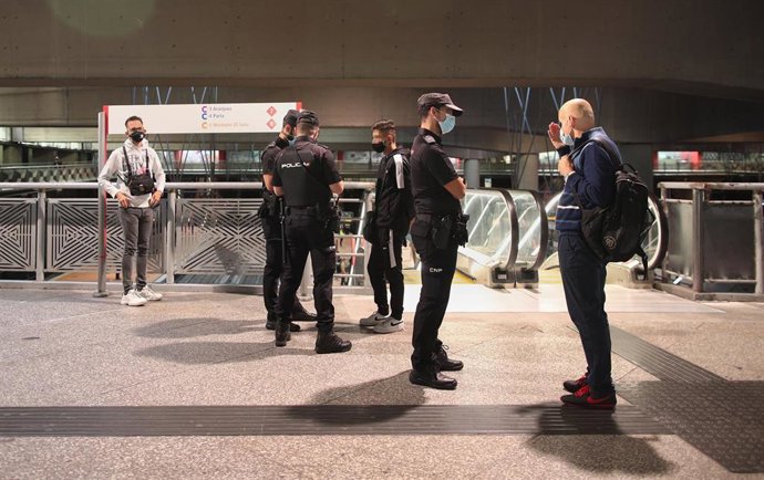 Agentes de la Policía Nacional revisan la documentación de varios pasajeros en la Estación de Madrid-Puerta de Atocha Adif, en Madrid.