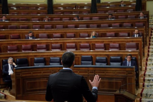 El presidente del Gobierno, Pedro Sánchez (de espaldas), interviene en el Congreso con los ministros Fernando Grande-Marlaska y Salvador Illa en el hemiciclo