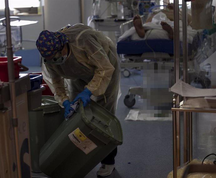 Imagen de archivo de una trabajadora de la limpieza mientras limpia una papelera durante su jornada laboral en la Unidad de Cuidados Intensivos (UCI) dedicada a enfermos de coronavirus 