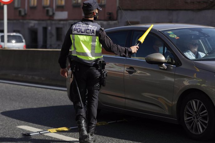 Un agente de Policía Nacional da el alto a un vehículo en un control en la carretera A-5, en Madrid (España), a 9 de octubre de 2020. El Ministerio del Interior ha comenzado a desplegar un amplio operativo de controles policiales en Madrid y el resto de