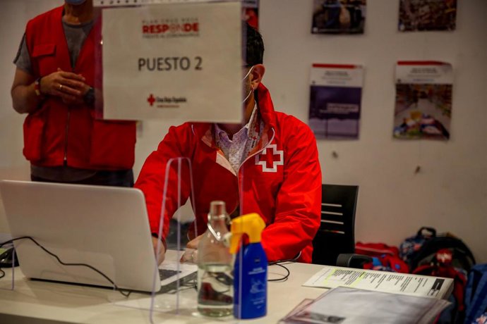 Treballadors atenen en la seva taula de treball a la seu de Creu Roja Espanyola a Sant Sebasti dels Reis, Madrid (Espanya),  2 d'octubre del 2020.