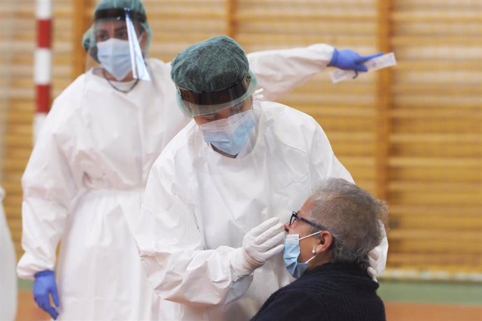 Una sanitaria toma muestras a una mujer a través de un frotis de nariz durante la realización de test de antígenos, foto de archivo