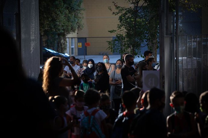 Pares i alumnes esperen a les portes d'una escola durant el primer dia del curs escolar 2020-2021, a Barcelona, Catalunya (Espanya), 14 de setembre del 2020.