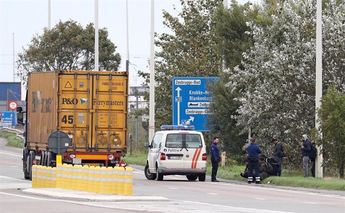 Migrantes detenidos junto a un camión 