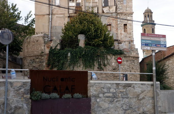 Pla general d'ampolles penjades al costat del cartell d'entrada al nucli antic de Calaf. Imatge del 10 d'octubre del 2020.