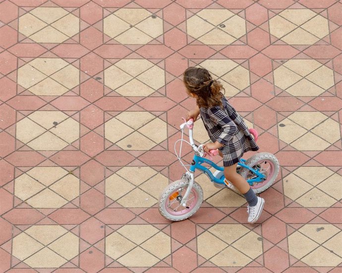 Una niña jugando con su bicicleta