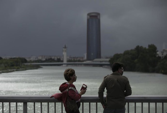 Dos personas caminan por el Puente de la Barqueta en Sevilla (Imagen de archivo)