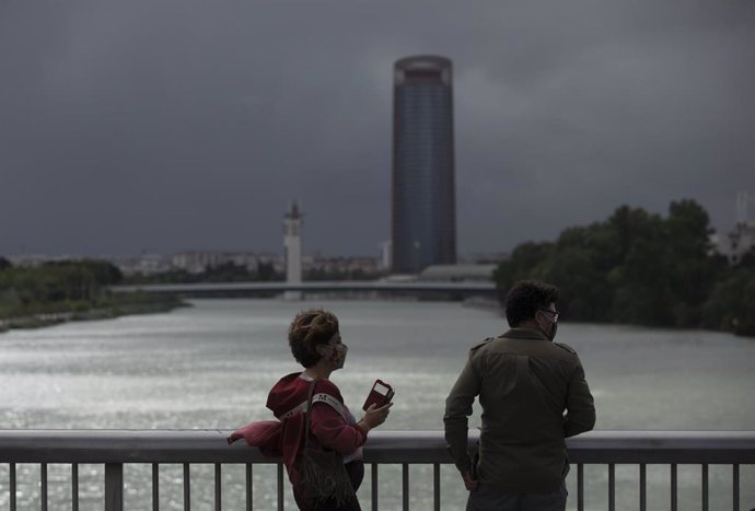 Dos personas caminan por el Puente de la Barqueta en Sevilla (Imagen de archivo)