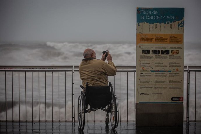 Un hombre hace una foto en el paseo marítimo de Barcelona