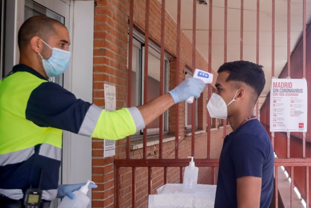 Un trabajador toma la temperatura a una de las personas que ha acudido durante la jornada de hoy a realizarse una prueba PCR al dispositivo instalado en el Centro de Especialidades El Arroyo, en Fuenlabrada, Madrid, (España), a 27 de agosto de 2020.