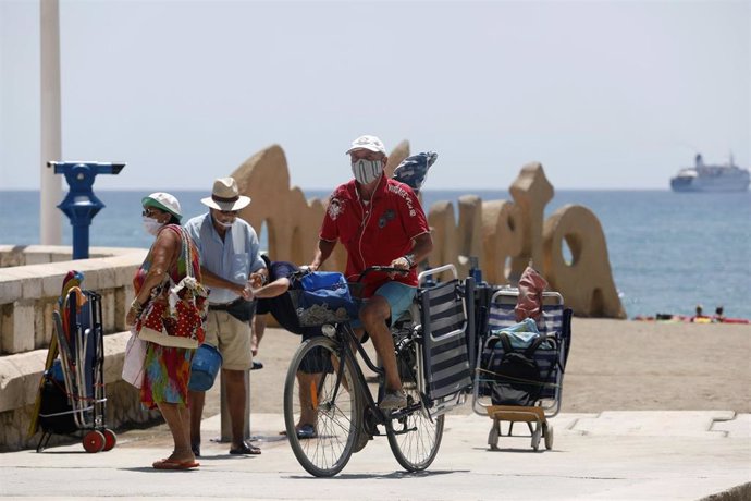 Bañistas con mascarillas en la playa de La Malagueta