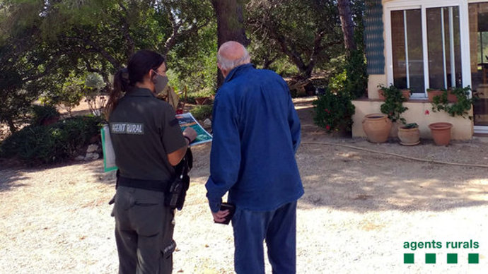 Pla mitj d'una Agent Rural informant un propietari del Perelló sobre els perímetres d'autoprotecció en cas d'incendi forestal. Imatge del 12 d'octubre del 2020 (horitzontal)