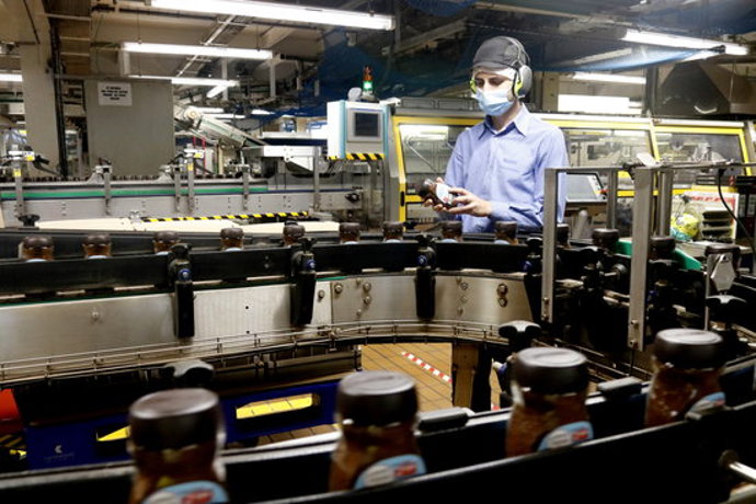 Un treballador inspecciona un pot de Nescafé al costat d'una de les línies de producció de la fbrica de Girona. Pla general. Imatge publicada el 13 d'octubre del 2020 (Horitzontal)