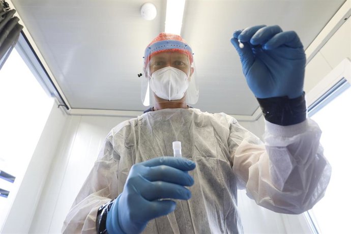 Un médico se prepara para hacer un test de COVID-19 en Bruselas