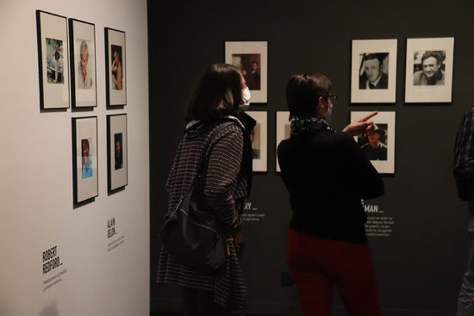 Pla general de dues dones mirant les fotos de l'exposició 'Actors (Icnics)' al Museu del Cinema el 13 d'octubre de 2020 (Horitzontal)