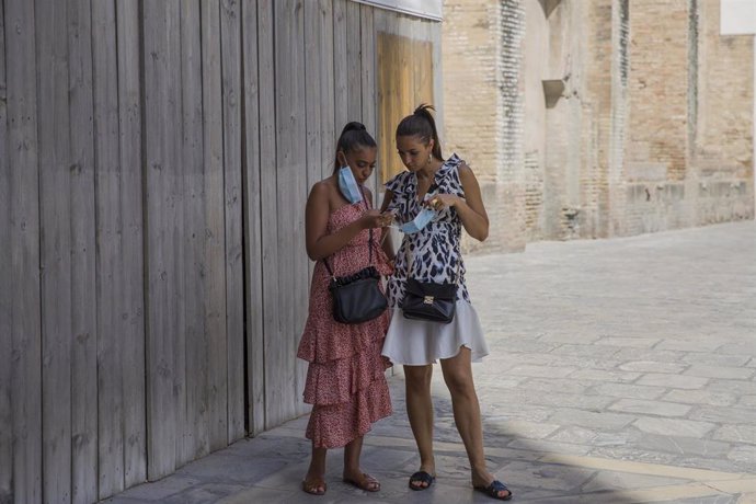Dos turistas mirando el móvil en el entorno de la Catedral