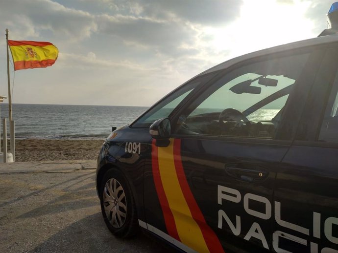 Un coche de la Policía Nacional frente al mar.